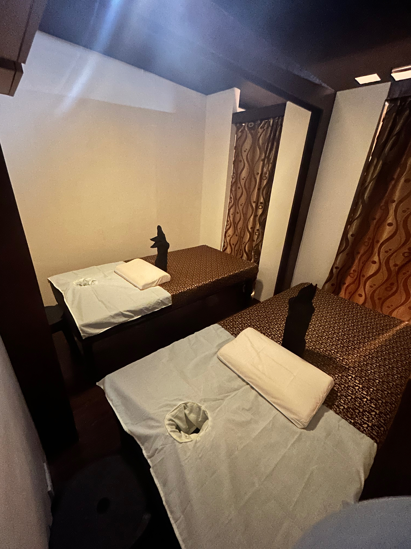 Twin Thai massage beds with silk runners in a private treatment room